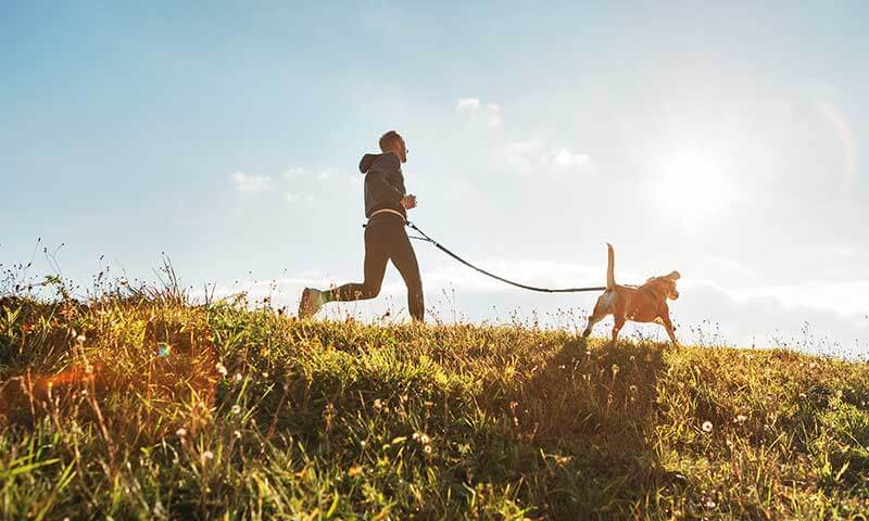 A man running with his dog